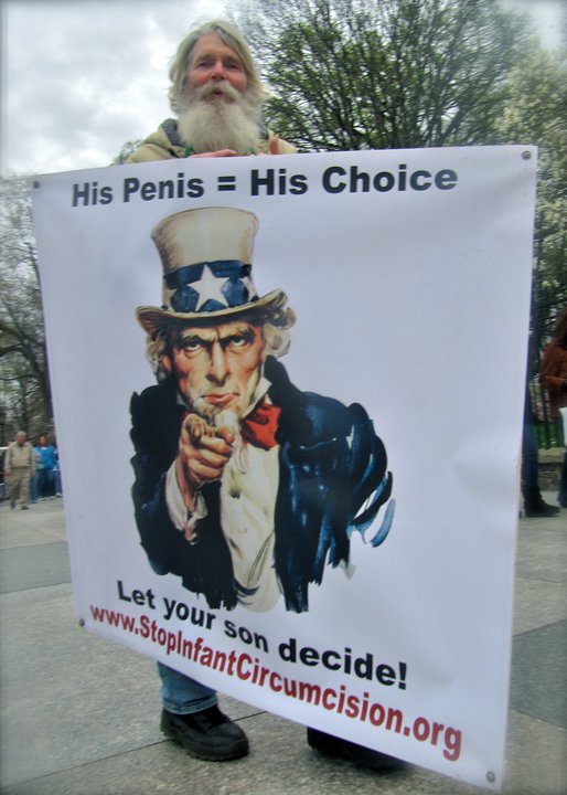 Intactivist Van Lewis holding a sign saying "His Penis = His Choice" and "Let your son decide"